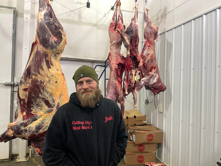 Josh Clark, manager at Cutting Edge Meat Market in Piedmont, S.D., is pictured in a meat locker.