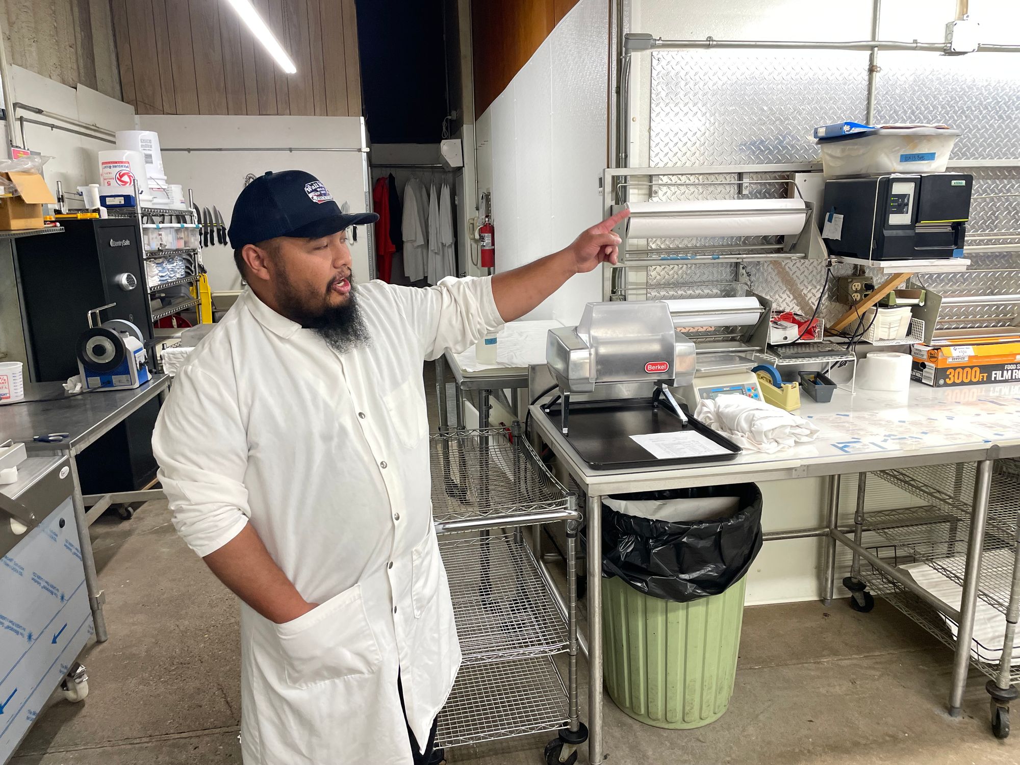 Chris Charfauros, manager of Wall Meat Processing, gestures while explaining the process behind meat packing.