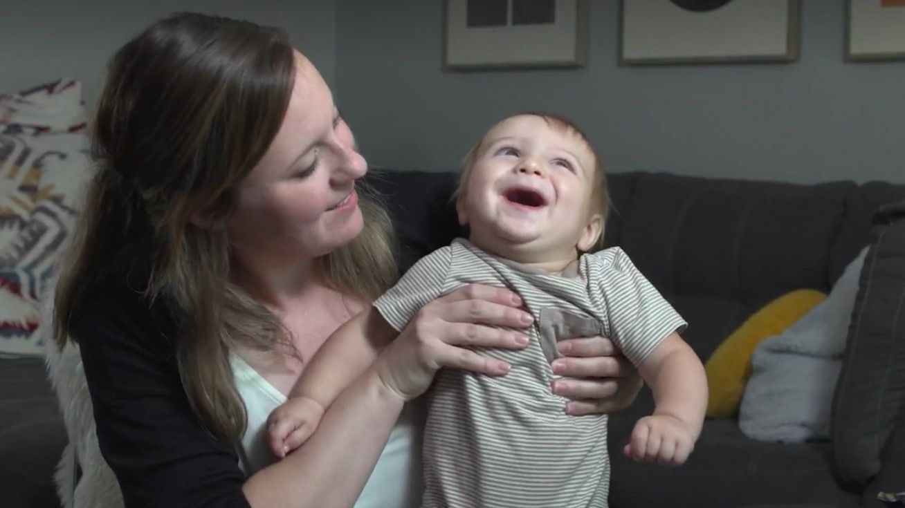 RiAnna Kolovsky holds up her child in her home