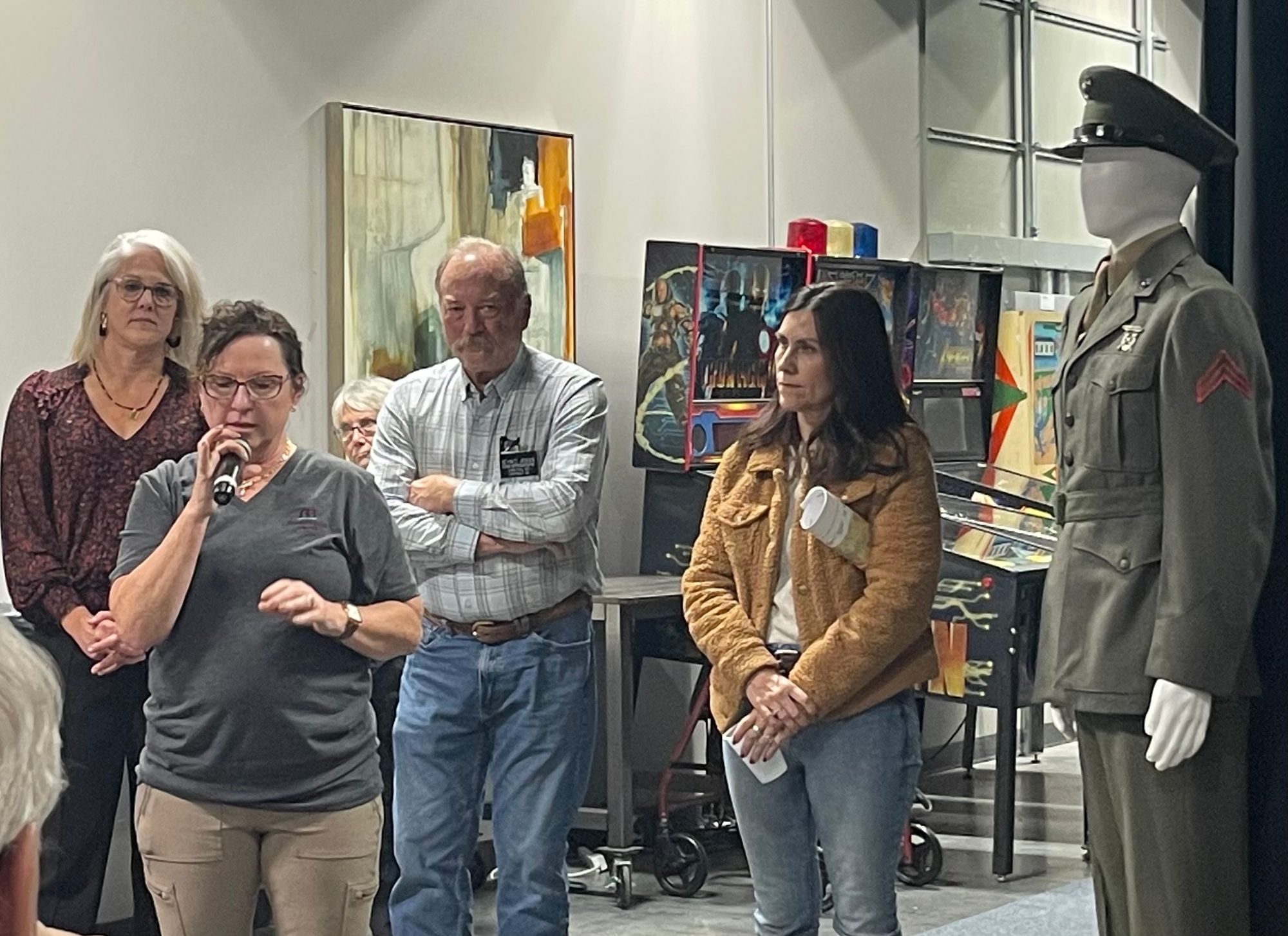 Minnehaha County Auditor Leah Anderson (with microphone) speaks at a South Dakota Canvassing Group event with people in the background.