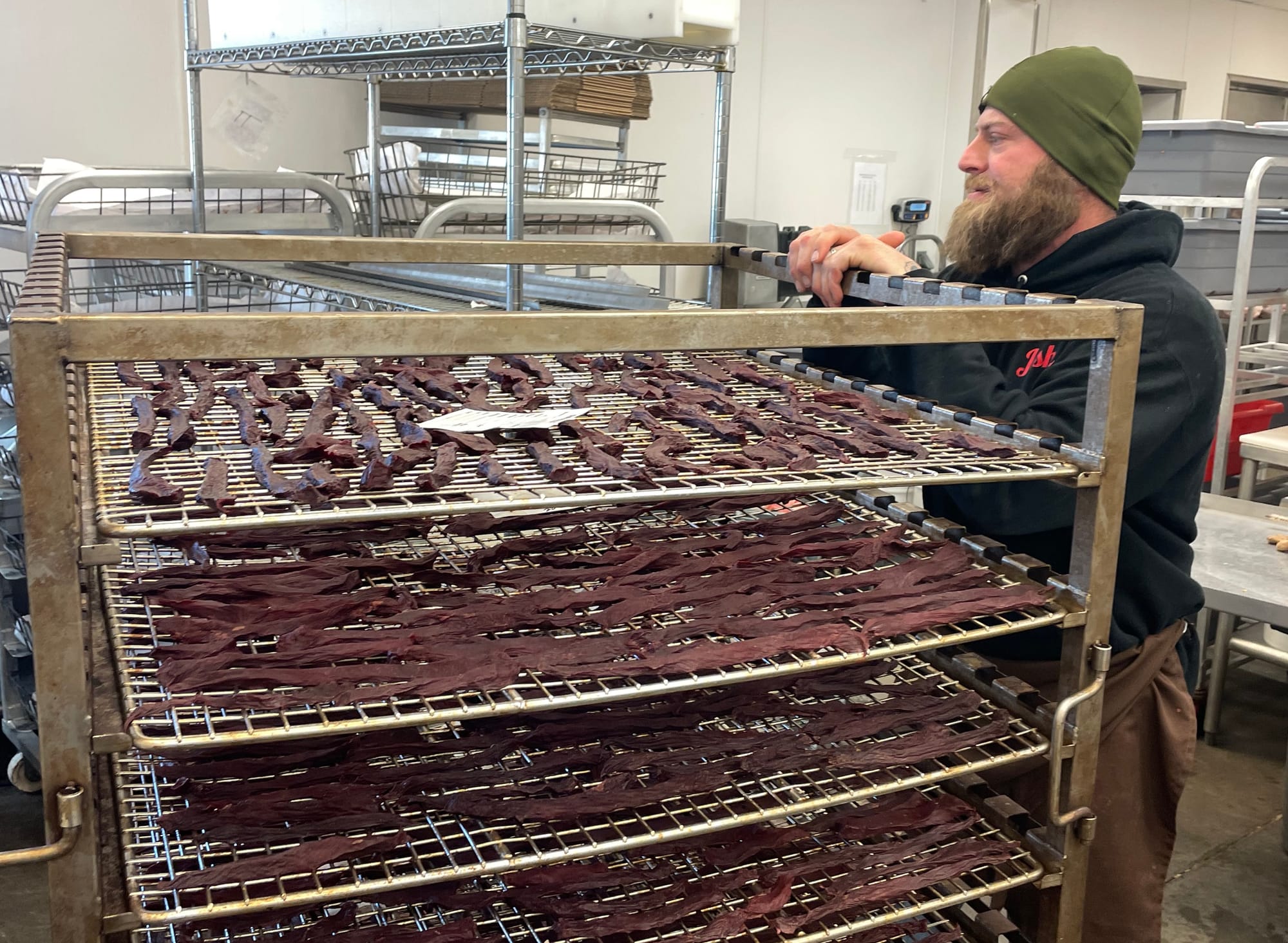 Josh Clark stands near a rack of drying venison jerky