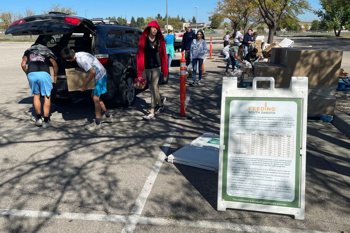 Students from Creekside Christian School in Rapid City help pack groceries into the trunks of cars during a recent mobile food bank event