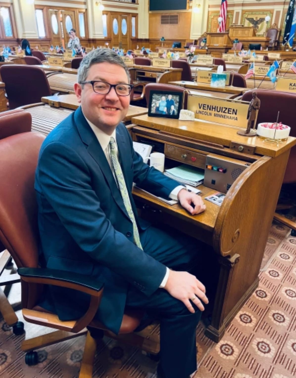 South Dakota Rep. Tony Venhuizen poses for a photo at his desk in the Legislature.