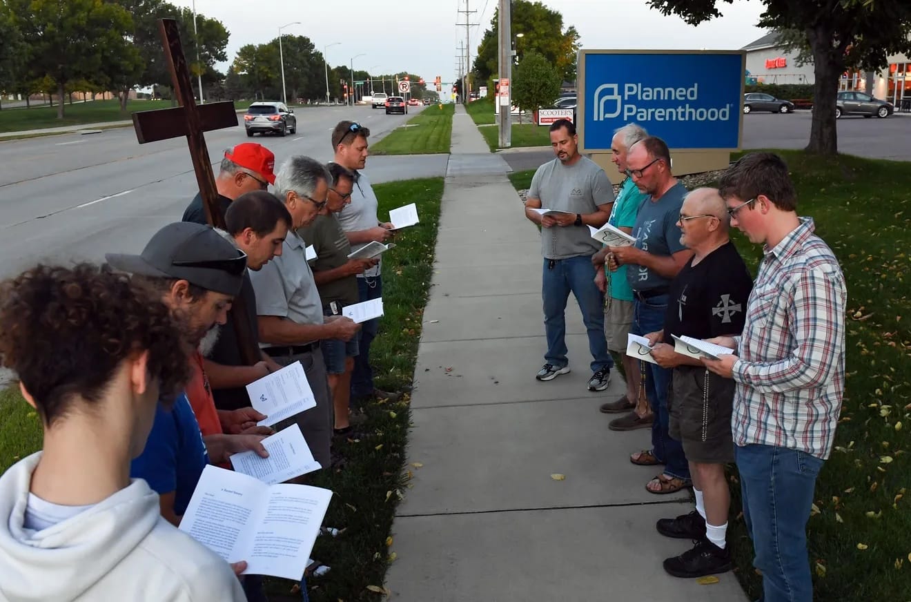 Members of Jericho Wall, an all-male anti-abortion prayer group, pray the rosary outside Planned Parenthood in Sioux Falls.