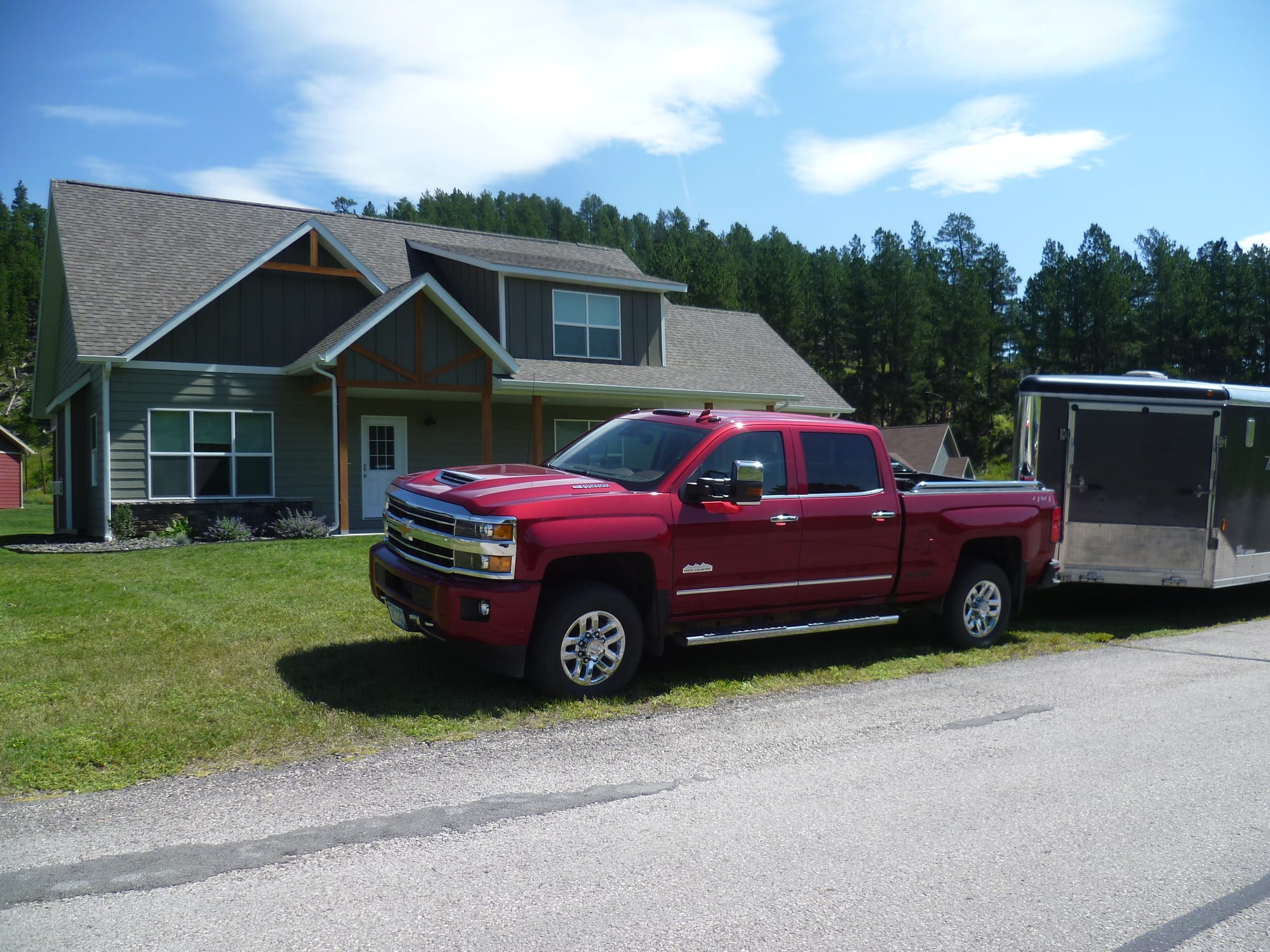 A truck and trailor is parked on the grass at a Hill City, South Dakota home.