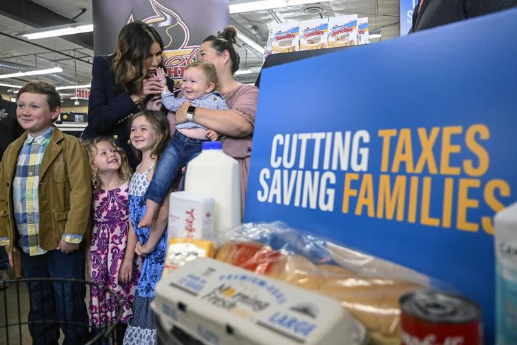 South Dakota Gov. Kristi Noem poses for a photo with a family in a grocery store