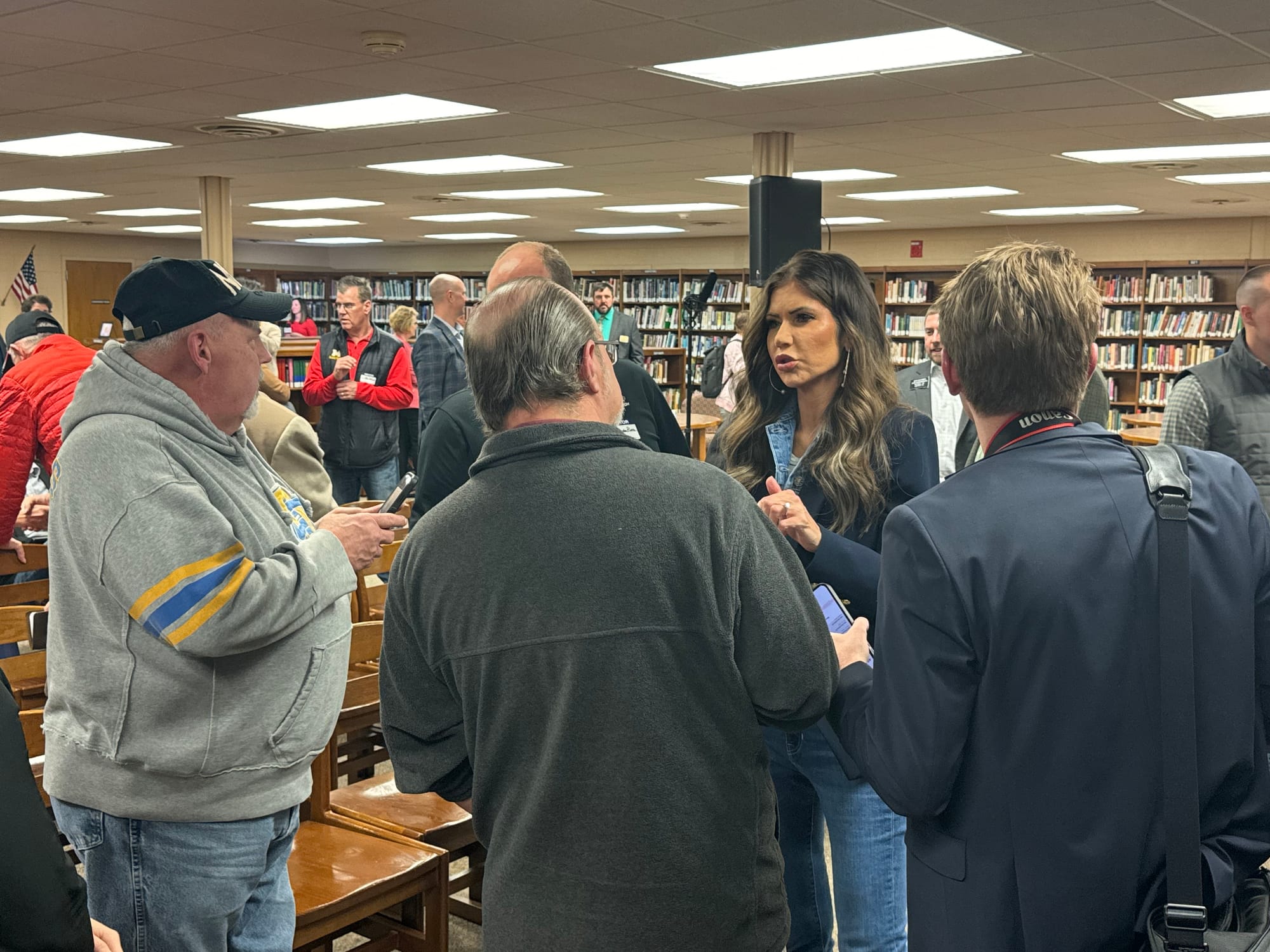 Gov. Kristi Noem speaks to reporters in a library