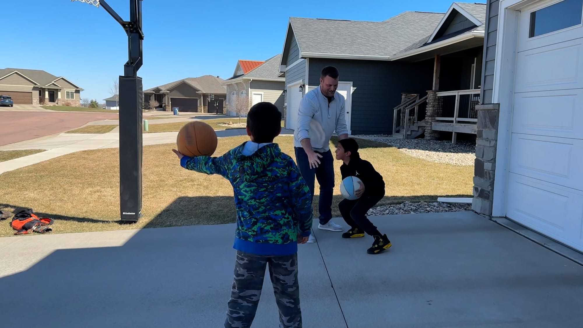 Scott Louwagie plays basketball with his two sons, both adopted from foster care, outside their home in Sioux Falls, S.D. 