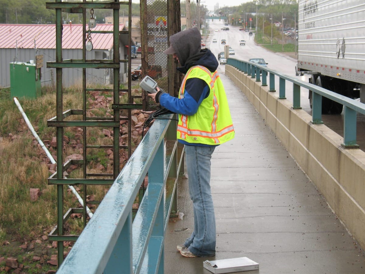 A man measures readings from the Big Sioux River in Sioux Falls, South Dakota