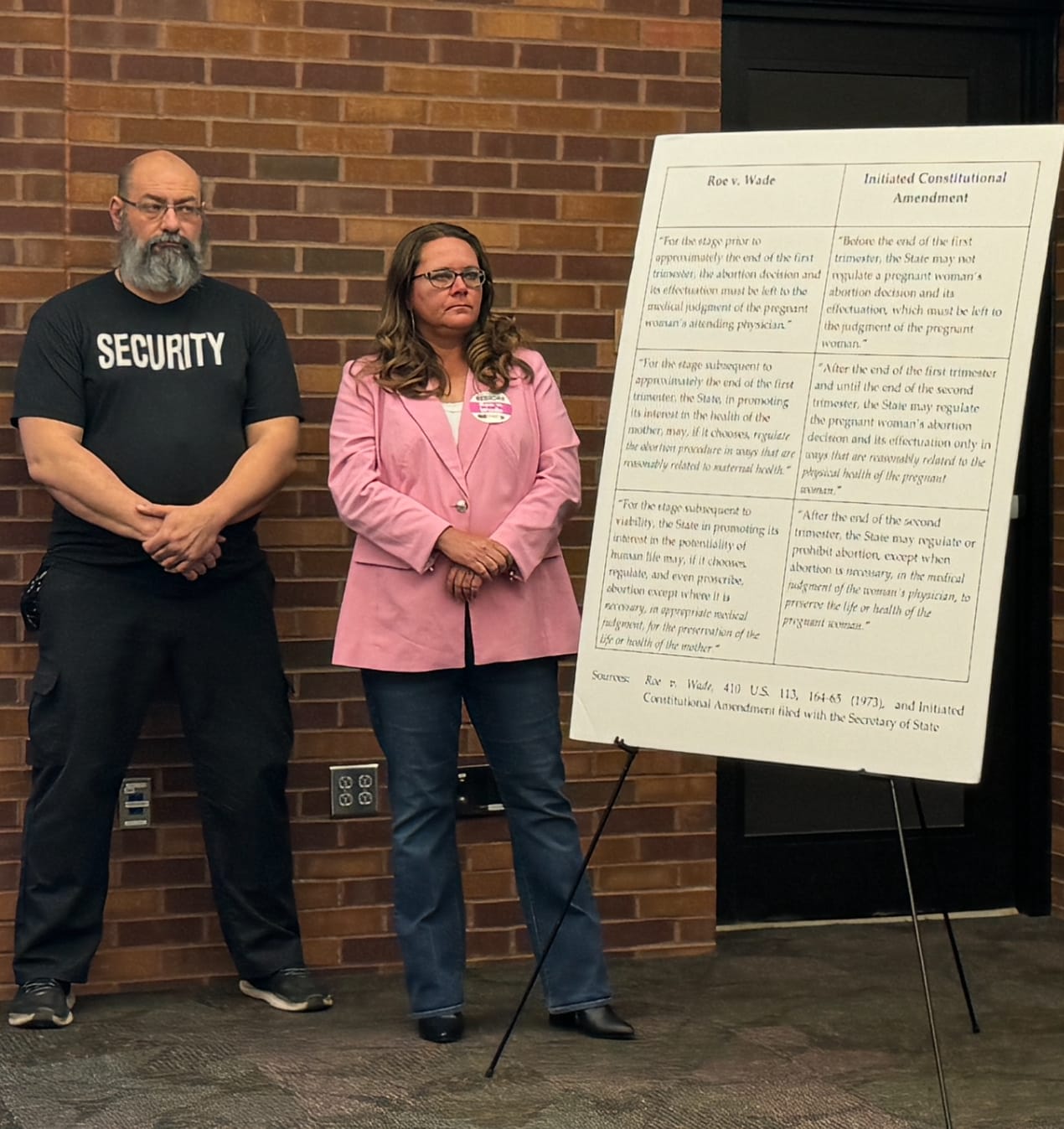 Tiffany Campbell of Dakotans for Health stands next to a security guard at a press conference May 1 at the downtown library in Sioux Falls. 