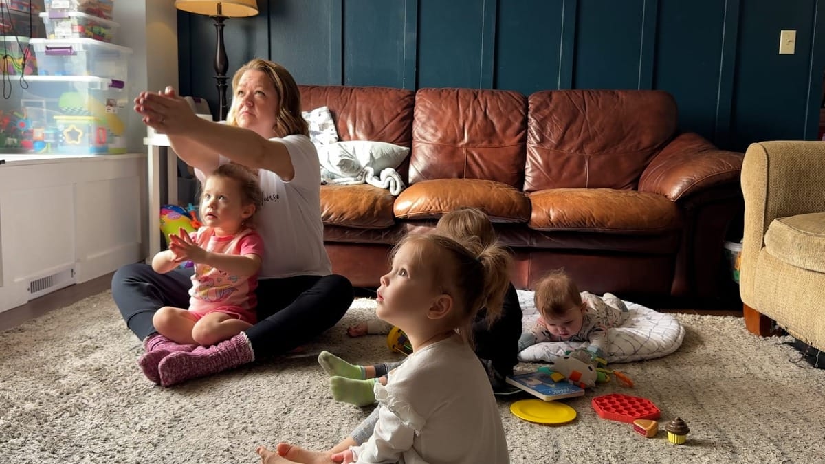 Karen Rieck and some of the children at her day care follow a yoga video to wind down 