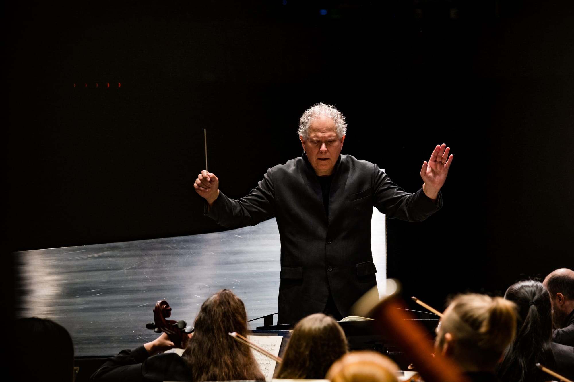 An orchestra conductor conducts the symphony