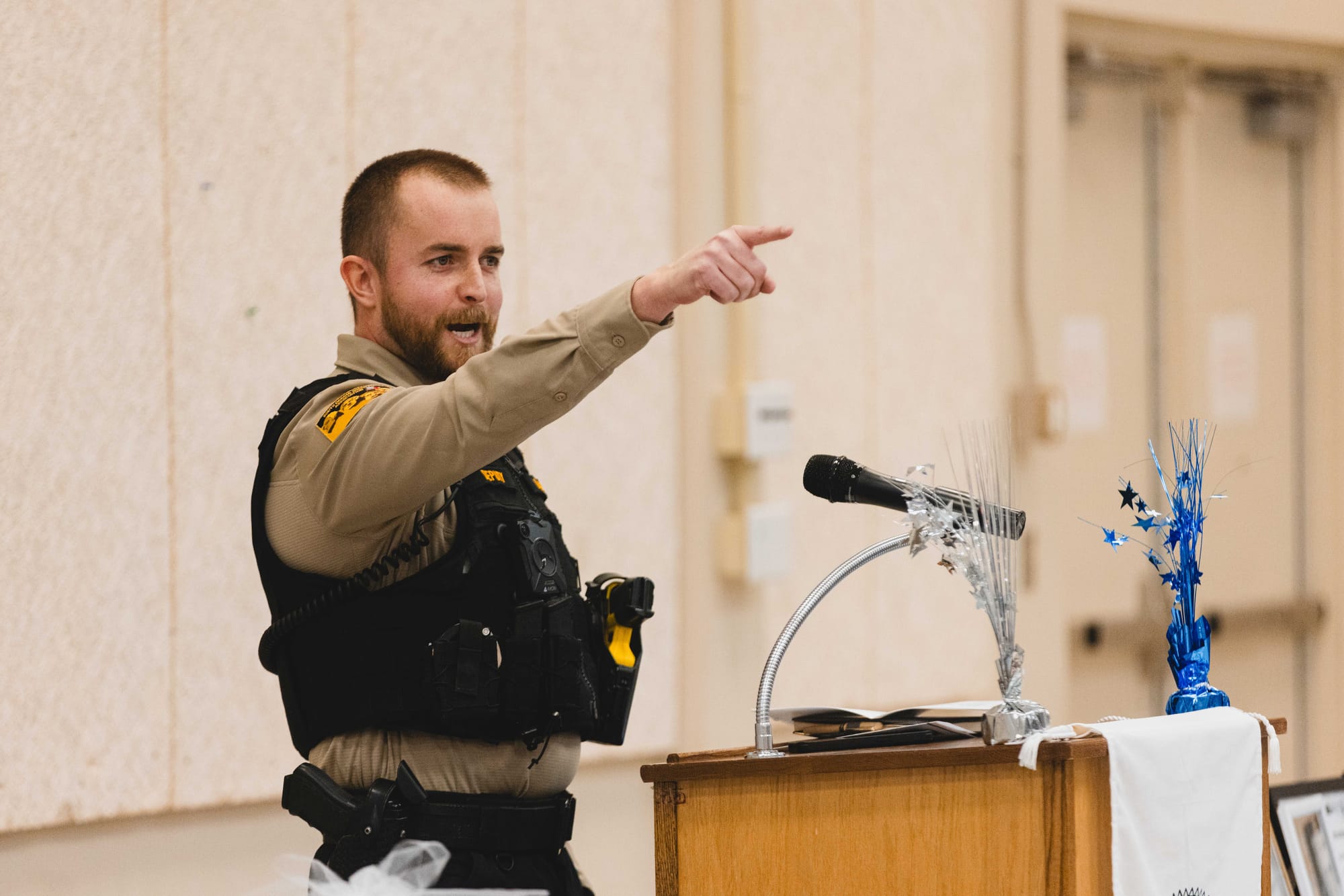 Grant Lanning tells graduates about the support of law enforcement officers in the back of the room at the James Valley Drug and DUI Court graduatio
