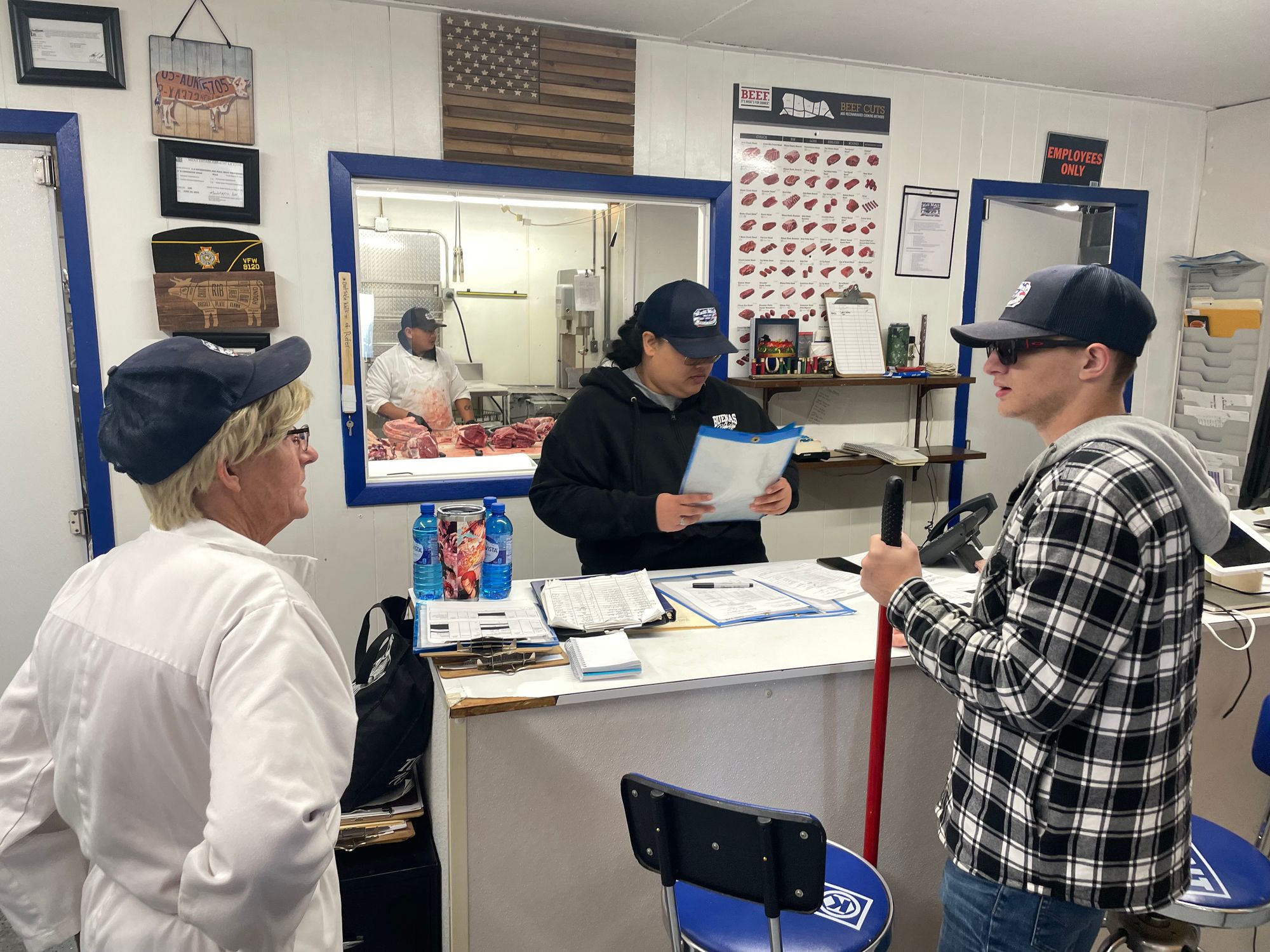 Workers look at documents at the Wall Meat Processing plant in Wall, South Dakota.