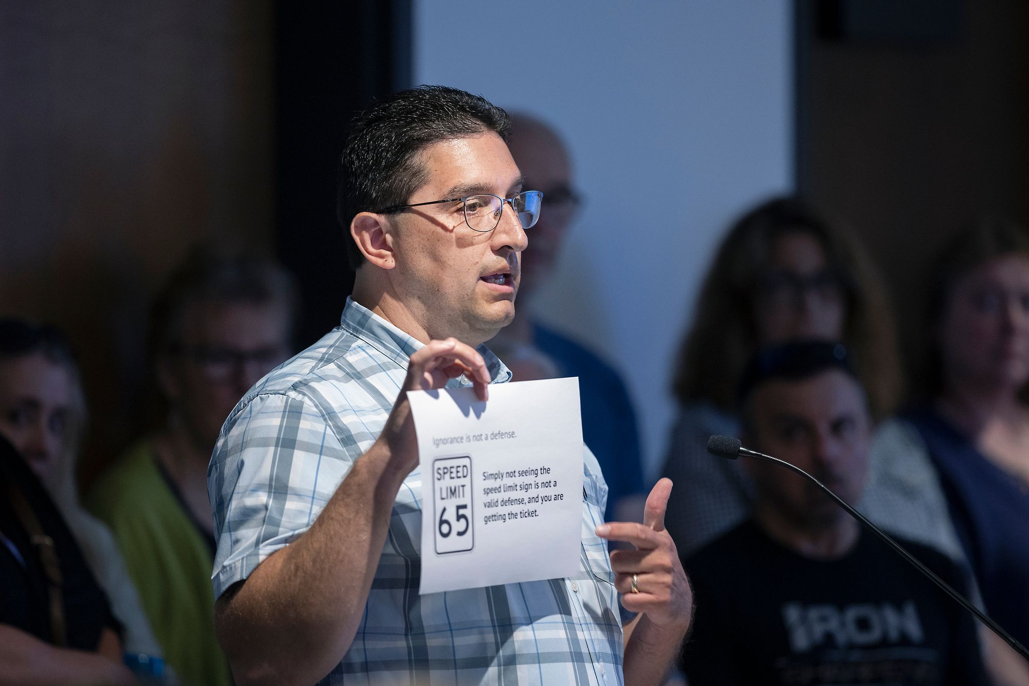 Rick Weible is shown speaking to a County of Board of Commissioners in Minnesota in 2022. He is holding up a piece of pap