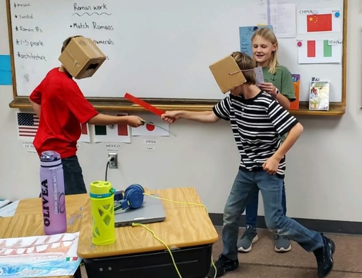 Two students at Bethesda Lutheran School in Hot Springs have a pretend battle using what they learned about the Roman Empire