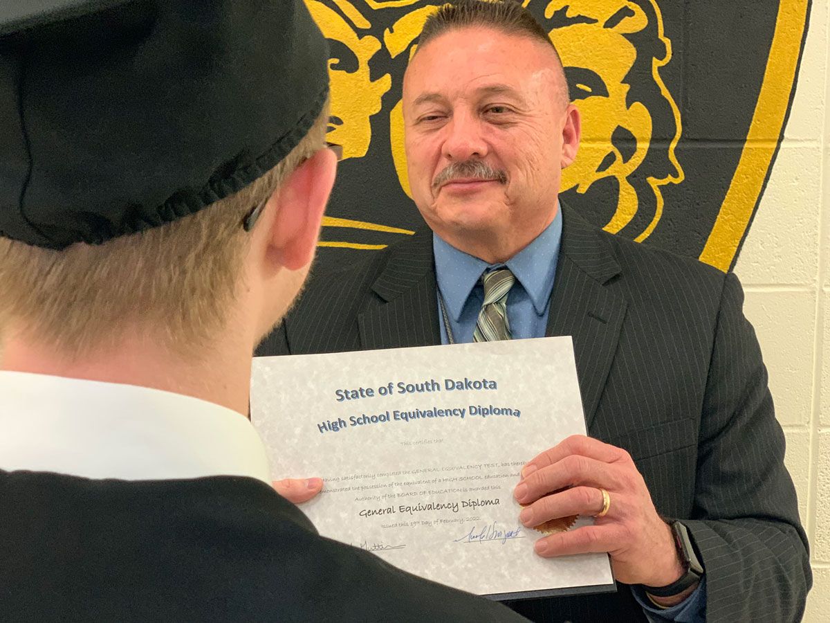 JSC Commander Joe Guttierez provides a diploma to a youth who completed the GED program in 2023. 