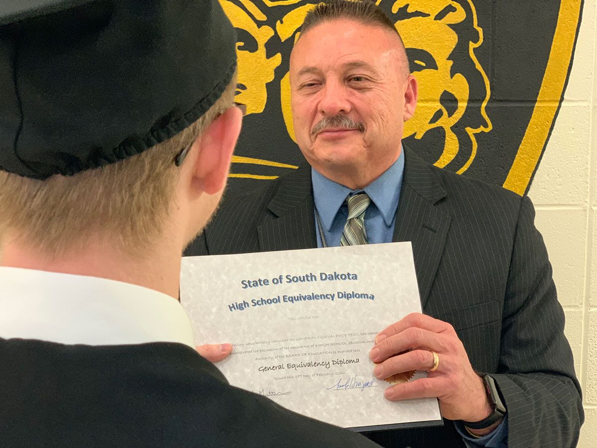 JSC Commander Joe Guttierez provides a diploma to a youth who completed the GED program in 2023.